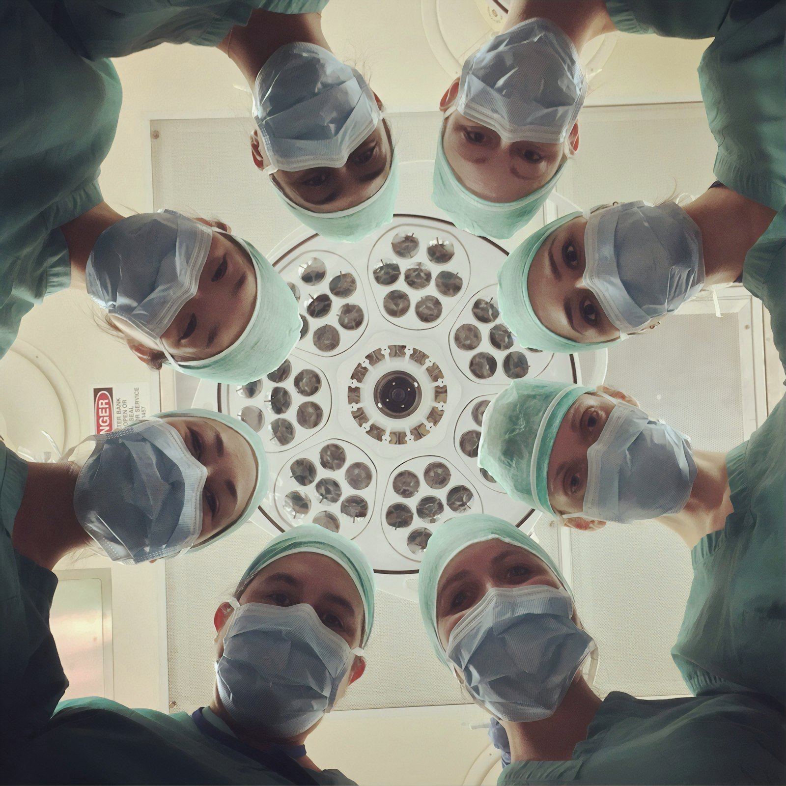 Surgical team gathered under an operating light